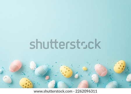 Top view photo of easter decorations yellow pink blue white eggs and sprinkles on isolated light blue background with copyspace