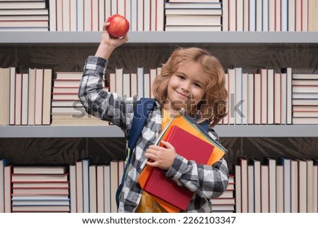 School boy with books and apple in library. Nerd school kid. Clever child from elementary school with book. Smart genius intelligence kid ready to learn. Hard study.