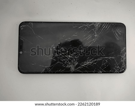 black color smartphone with cracked screen - isolated on white background