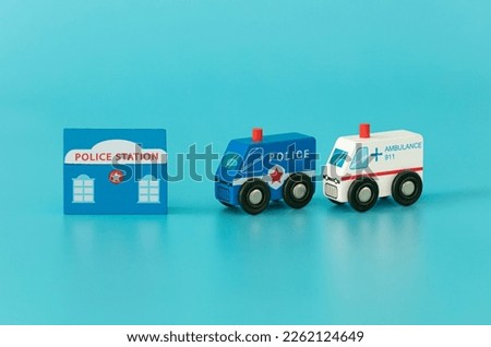 Wood sings: police station, ambulance and stop sign on blue background isolated. Symbols: wood toys for kids.