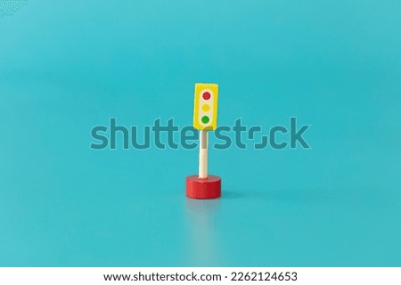 Wood yellow  traffic lights sings on blue background isolated. Symbols wood toys for kids.