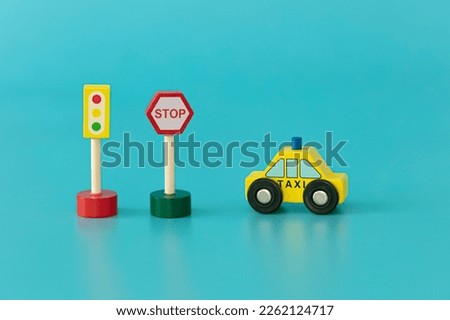 Wood sings: traffic light and stop sigs with yellow taxi on blue background isolated. Symbols: wood toys for kids.