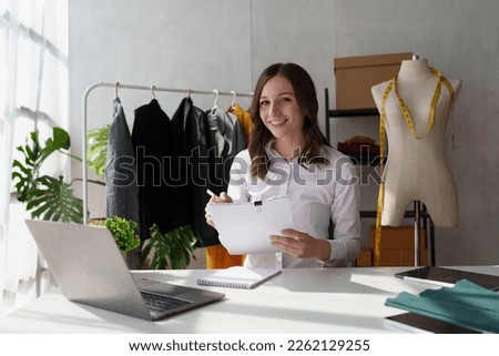 Beautiful young professional stylist working at design studio interior. fashion designer concept