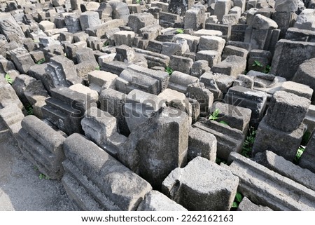 View of row of unidentified stone blocks from ancient temple ruin in Indonesia, for archeological study and research.