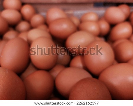 Blurred raw brown chicken eggs pile as background flat lay view for editing and copy space