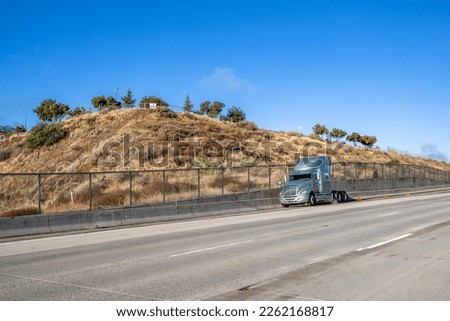 Broken big rig semi truck tractor with accident warning emergency signs standing on the road shoulder waiting for towing truck for the diagnostic technician inspection and quick repair