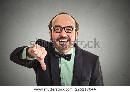 Closeup portrait sarcastic middle aged man showing thumbs down sign hand gesture happy someone made mistake lost failed isolated grey wall background. Negative emotion face expression feeling attitude