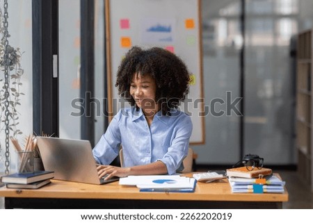 Accountant Young african businesswoman in afro hairstyle Using Calculator For documents Accounting financial sitting at computer in workplace office  Royalty-Free Stock Photo #2262202019