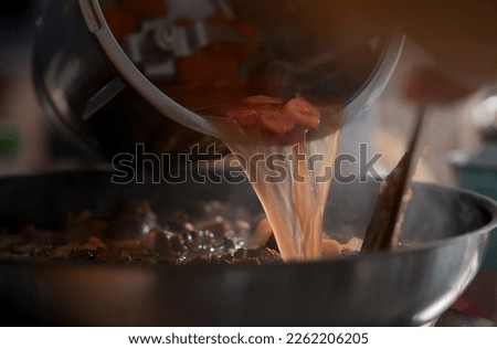 Pouring vegetable stock in the sauce