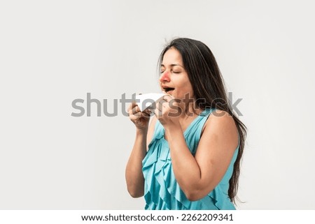 Mid aged Indian woman with tissue sneezing on white background. Runny nose Royalty-Free Stock Photo #2262209341