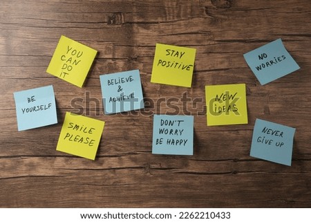 Paper notes with life-affirming phrases on wooden table, flat lay Royalty-Free Stock Photo #2262210433