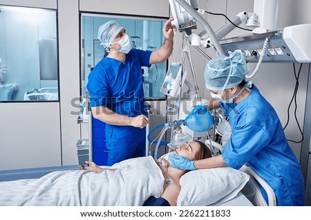 Nurse and doctor using medical ventilator on female patient while cardiopulmonary resuscitation in ICU and monitoring health. CPR in ICU
