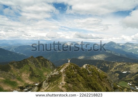 Happy woman on highest ridge top landscape photo. Beautiful nature scenery photography with mountains on background. Ambient light. High quality picture for wallpaper, travel blog, magazine, article
