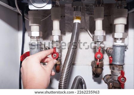 Plumbing connections of a modern domestic double-circuit gas boiler, water heater.                                  Royalty-Free Stock Photo #2262235963