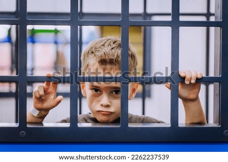 Little boy, child punished, locked up for bad behavior. Photography, quarantine and sickness concept. Portrait, ban. Royalty-Free Stock Photo #2262237539