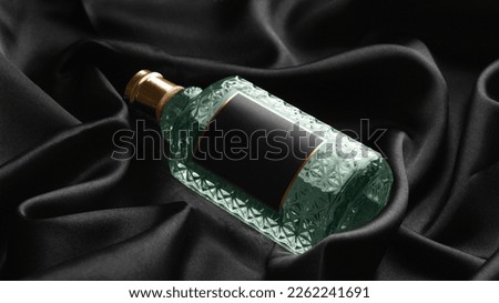 Luxury bottle of perfume on black silk, closeup