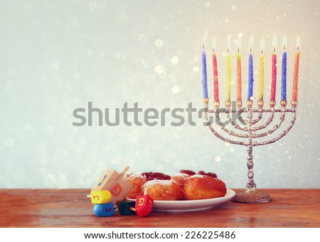 Image of jewish holiday Hanukkah with menorah, doughnuts and wooden dreidels (spinning top). r