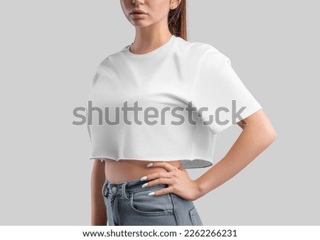 White t-shirt template, crop top on a girl in jeans, isolated on background, side view. Free cut t-shirt mockup, empty clothes oversized. Fashion shirt for design, print, brand, advertising