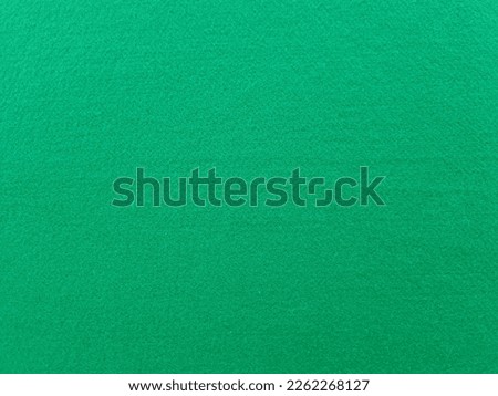 Texture of felt fabric in dark green color for background. Casino golf course
