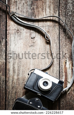 Old retro camera on vintage wooden boards abstract background 