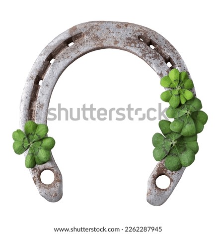 Old rusty horseshoe and four leaf clover isolated on white background