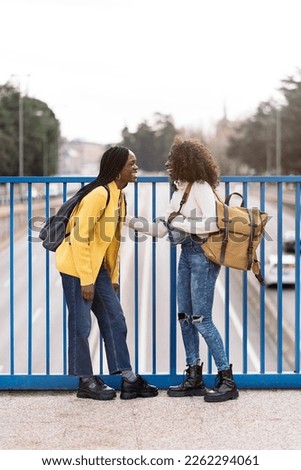 Stock photo of happy female black friends laughing and enjoying evening in the city.