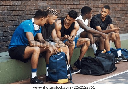 Basketball, sports and phone with a team talking on a court bench after a game or match outdoor. Teamwork, technology and conversation with a man athlete group chatting after exercise or fitness