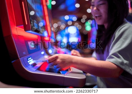 Slot Machine Play Time. Female Gambler Hand hold money bill ready to win the game with one best shot casino close up Royalty-Free Stock Photo #2262330717