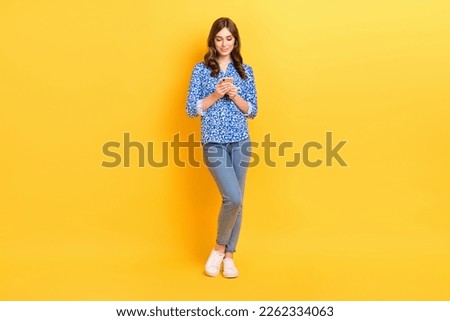 Full size portrait of nice lovely girl hold use telephone write typing blog post isolated on yellow color background
