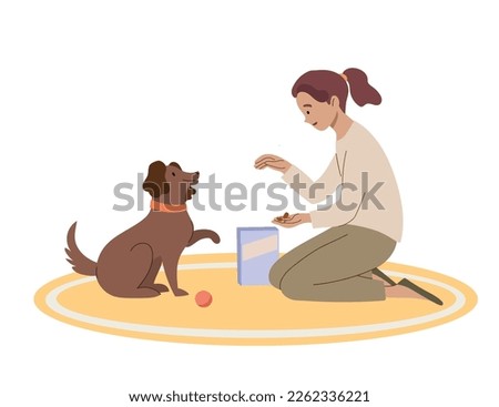 Girl gives friendly dog a treat. The owner trains pet to give a paw. Royalty-Free Stock Photo #2262336221