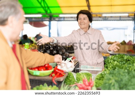 Positive mature casual saleswoman working with fresh