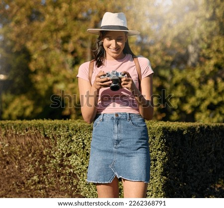 Photography, film and woman with a camera in nature for travel memory in Sweden. Summer, tourist and photographer looking at photos while traveling on a vacation in a park or botanical garden