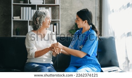 Kind nurse together with elderly woman in the hospital's or home in sofa
