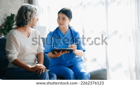 Kind nurse together with elderly woman in the hospital's or home in sofa
