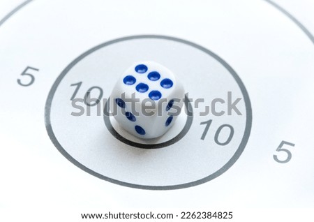 Game die showing six in the middle of a round shooting target, 6, 10, bullseye, good, perfect aim, goal achieving, winning, luck, risk,  high probability and chance abstract concept, nobody, no people Royalty-Free Stock Photo #2262384825