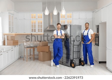 Male movers with refrigerator in new house