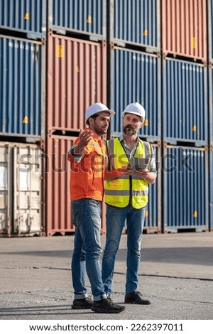 Logistics engineer and inspector working togetter and discussing with Shipping container stacker background in commercial transport port 