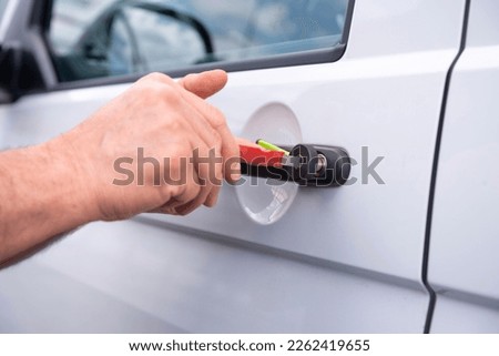Locksmith opening a locked car door Royalty-Free Stock Photo #2262419655