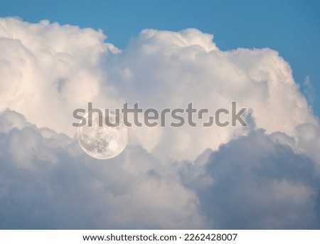 the moon against the clouds.morning moonset in the morning.full moon in the morning