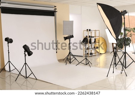 Interior of modern photo studio with white cyclorama and equipment