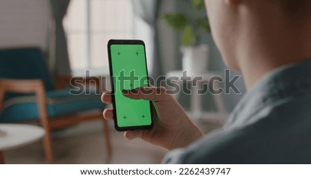 Close up shot of a man using smartphone with chroma key green screen, scrolling through social media or online shopping - technology, connection concept 