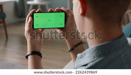 Man using a smart phone with mock up green screen, talking while having an online conference - online education, communications concept close up