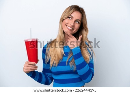 Young Uruguayan woman drinking soda isolated on white background happy and smiling