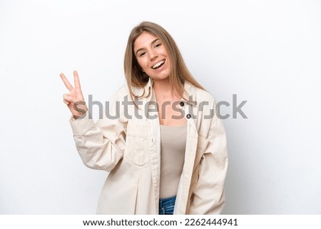 Young caucasian woman isolated on white bakcground smiling and showing victory sign