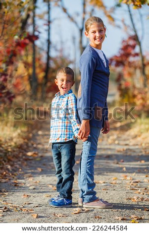 Adorable cute boy and girl has fun in the beautiful autumn park