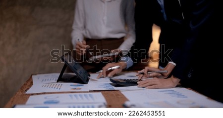Meeting of business people pointing at graphs and charts to analyze market data, balance sheet, account, net profit, to formulate new sales strategy to increase productivity using laptop computer. Royalty-Free Stock Photo #2262453551