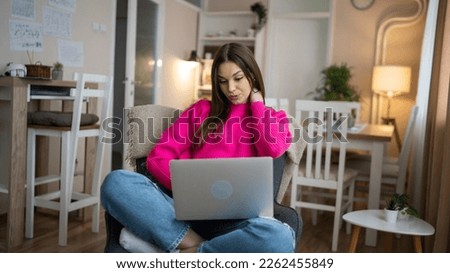 One young woman use laptop computer at home while sit comfortable browsing internet or work online watching video at her apartment real people copy space