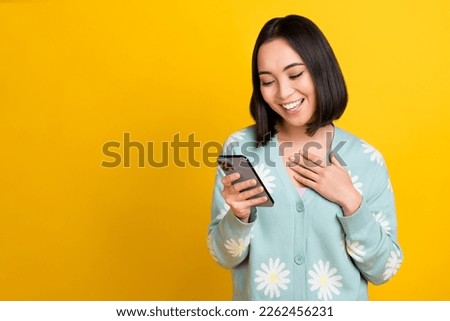 Photo of cheerful woman with bob hairdo dressed blue pullover hold phone read email hand on chest isolated on yellow color background
