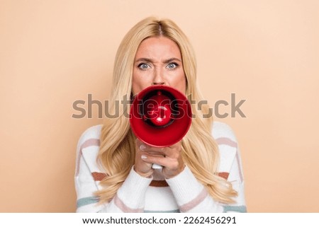 Photo of aggressive businesswoman hold megaphone loud speaker screaming protest slogan against modern taxes isolated on beige color background