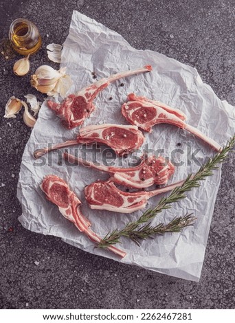 Raw lamb meat chops steaks, on old dark wooden table background, top view flat lay